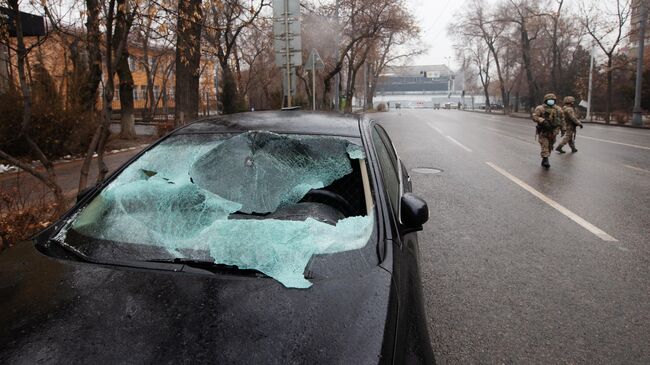 Поврежденный автомобиль в результате погромов в Алма-Ате