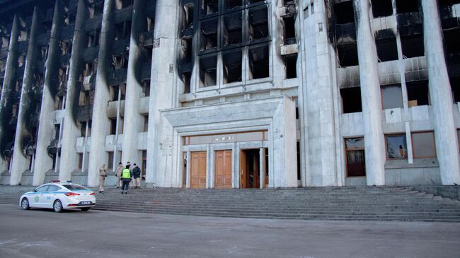 Сотрудники полиции возле пострадавшего от пожара здания Акимата в Алма-Ате