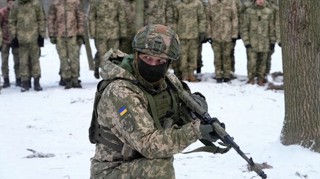 Инструктор во время тренировки военнослужащих в городском парке в Киеве