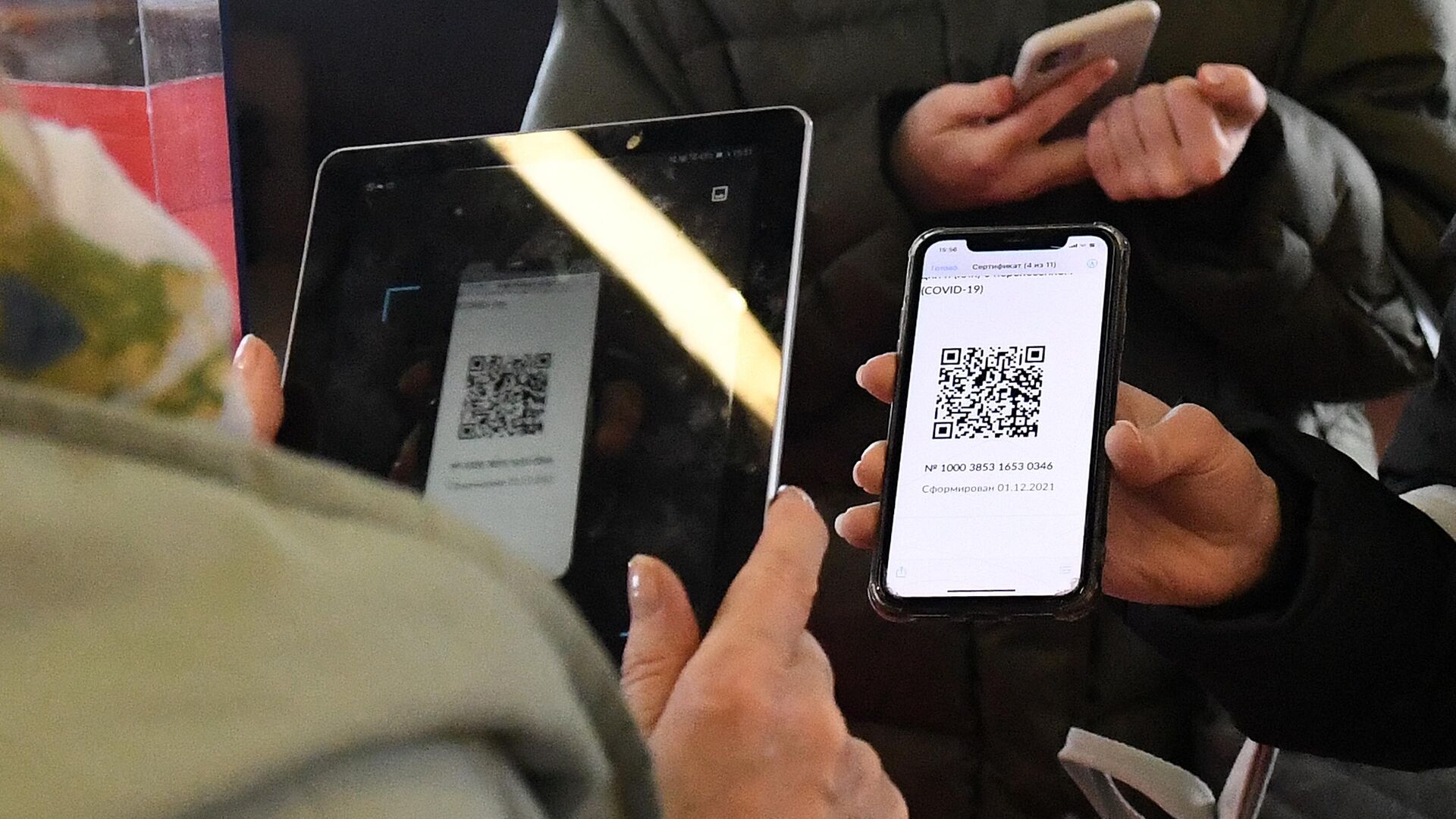 Сотрудница музея проверяет наличие QR-кода о вакцинации от CoVID-19 у посетителя музейного центра Площадь Мира в Красноярске - РИА Новости, 1920, 03.03.2022