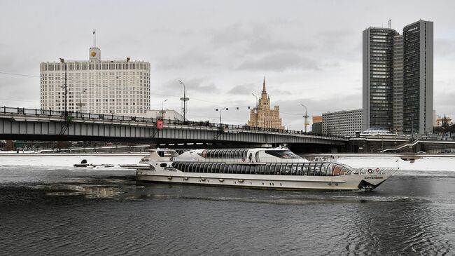 Теплоход проплывает под Новоарбатским мостом в Москве. Слева: Дом правительства РФ