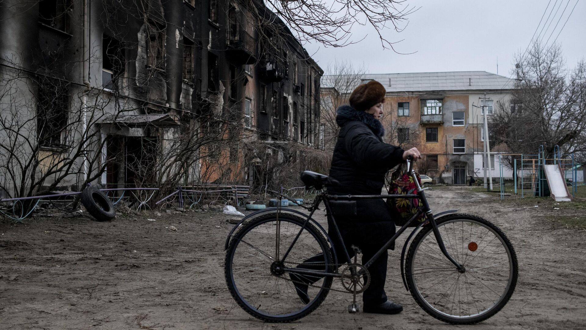 Женщина везет велосипед во дворе жилого дома в городе Счастье в Луганской народной республике - РИА Новости, 1920, 02.03.2022