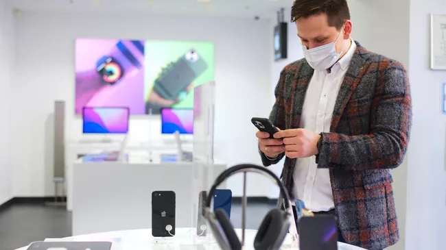 Покупатель выбирает гаджет Apple. Архивное фото.
