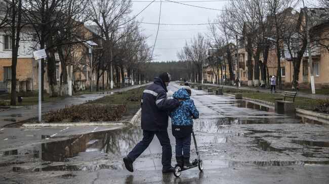 Мужчина с мальчиком на улице в городе Счастье в Луганской народной республике