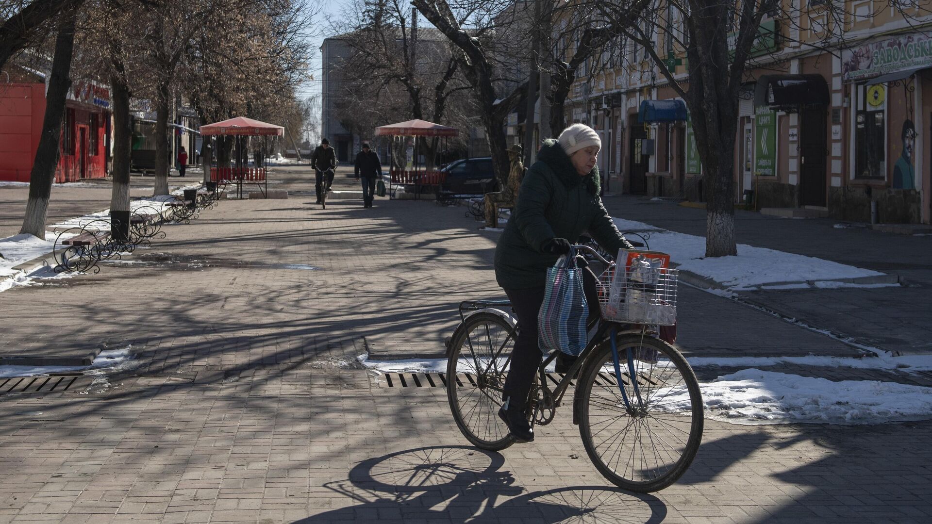 Местная жительница едет на велосипеде на одной из улиц в городе Старобельск - РИА Новости, 1920, 14.03.2022