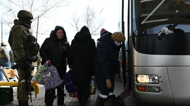 Жители города перед посадкой в автобус, следующий из Мариуполя