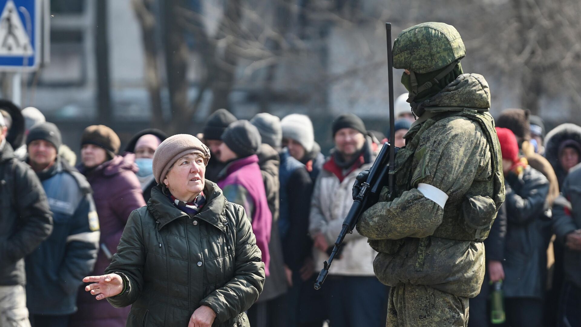 Женщина из очереди, где люди ожидают выдачу гуманитарной помощи, разговаривает с военнослужащим - РИА Новости, 1920, 02.04.2022