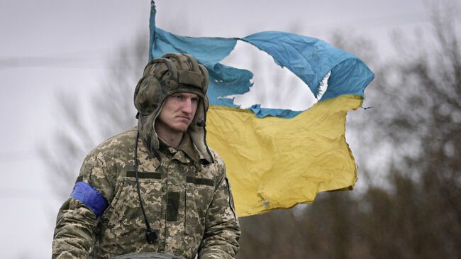 Украинский военнослужащий под Киевом на фоне флага Украины