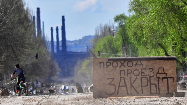 Мальчик катается на велосипеде на одной из улиц в Мариуполе