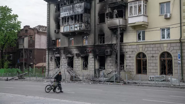 Местный житель возле разрушенного жилого здания в Мариуполе
