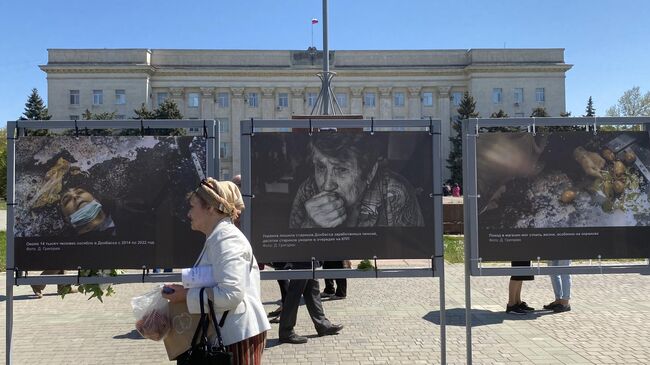 Женщина на площади Свободы в Херсоне, где открылась фотовыставка о преступлениях ВСУ в Донбассе