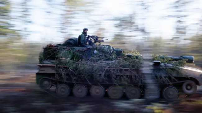 Финские военнослужащие едут на танке во время учений