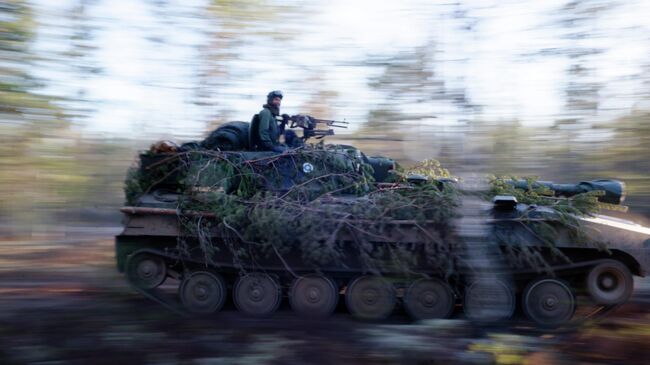 Финские военнослужащие едут на танке во время учений