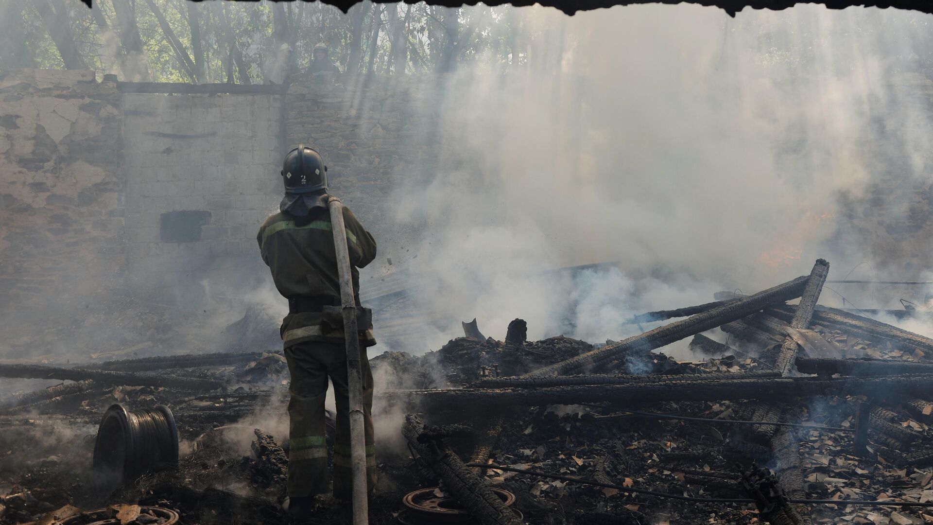 Пожарный МЧС ДНР тушат пожар на мебельном складе в Донецке, возникший после обстрела со стороны ВСУ - РИА Новости, 1920, 13.06.2022