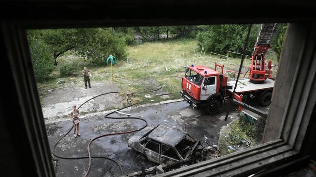 Машина МЧС ДНР возле дома, где возник пожар в результате обстрелов со стороны ВСУ Донецка 