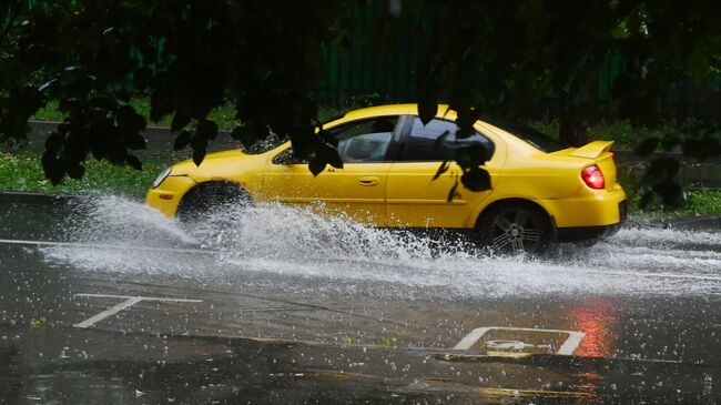 Автомобиль на дороге во время сильного дождя в Москве. Архивное фото