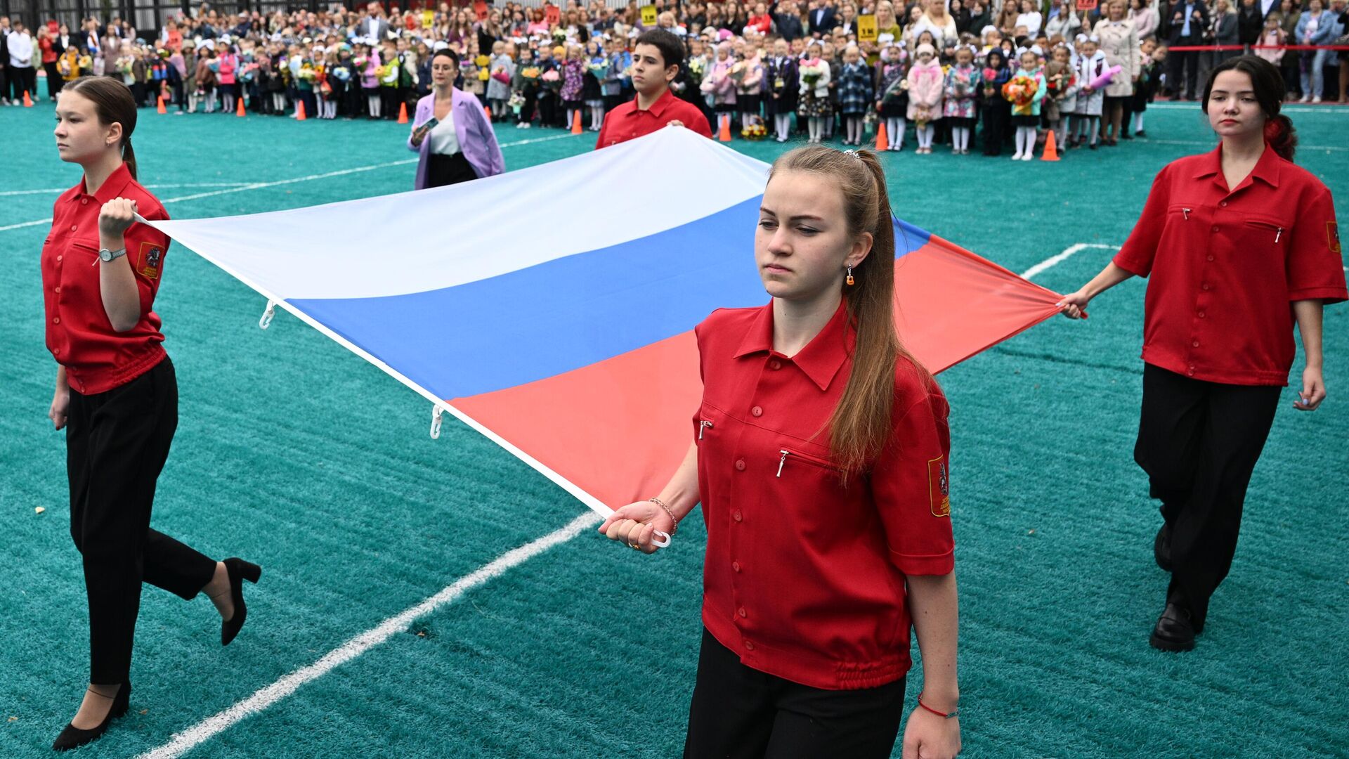 Учащиеся во время церемонии поднятия государственного флага России на торжественной линейке в День знаний, проходящей в школе №158 в Москве - РИА Новости, 1920, 12.12.2024