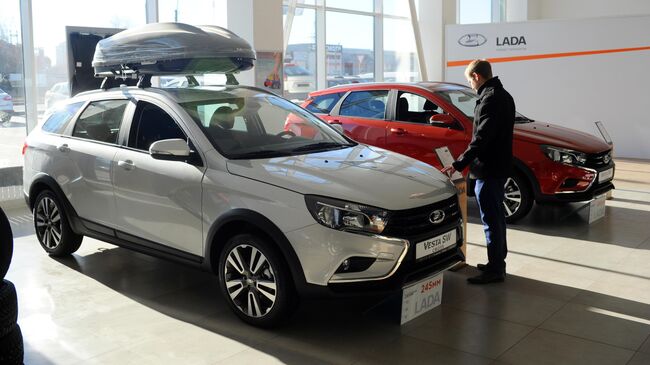 Посетитель рассматривает автомобиль Lada Vesta 