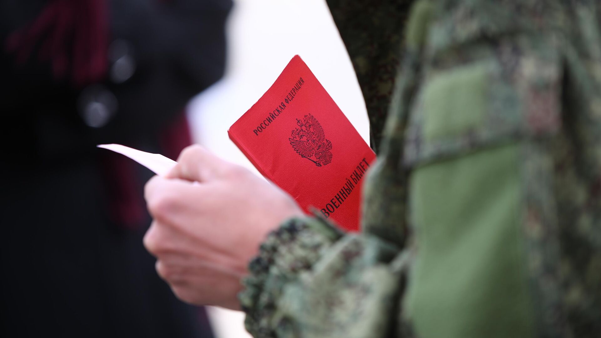 Военный билет в руках мужчины, призванного на воинскую службу в ходе частичной мобилизации - РИА Новости, 1920, 25.09.2022