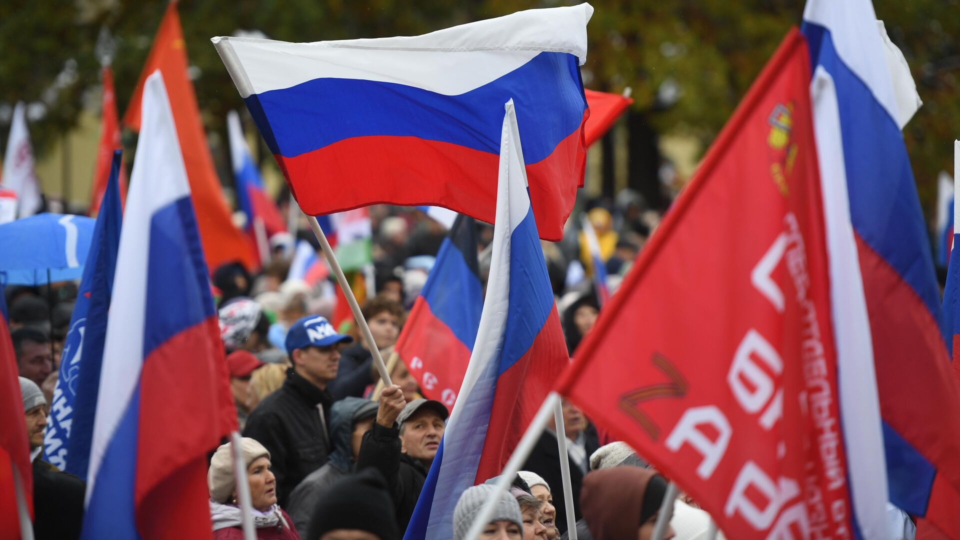 Люди с флагами во время митинга-концерта в честь присоединения ЛНР, ДНР, Херсонской и Запорожской областей к России в Центральном парке Новосибирска - РИА Новости, 1920, 26.11.2024