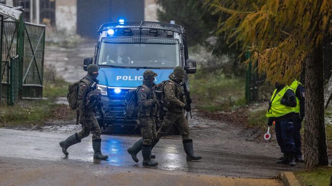 Польские военные неподалеку от места попадания ракеты в деревне Пшеводув