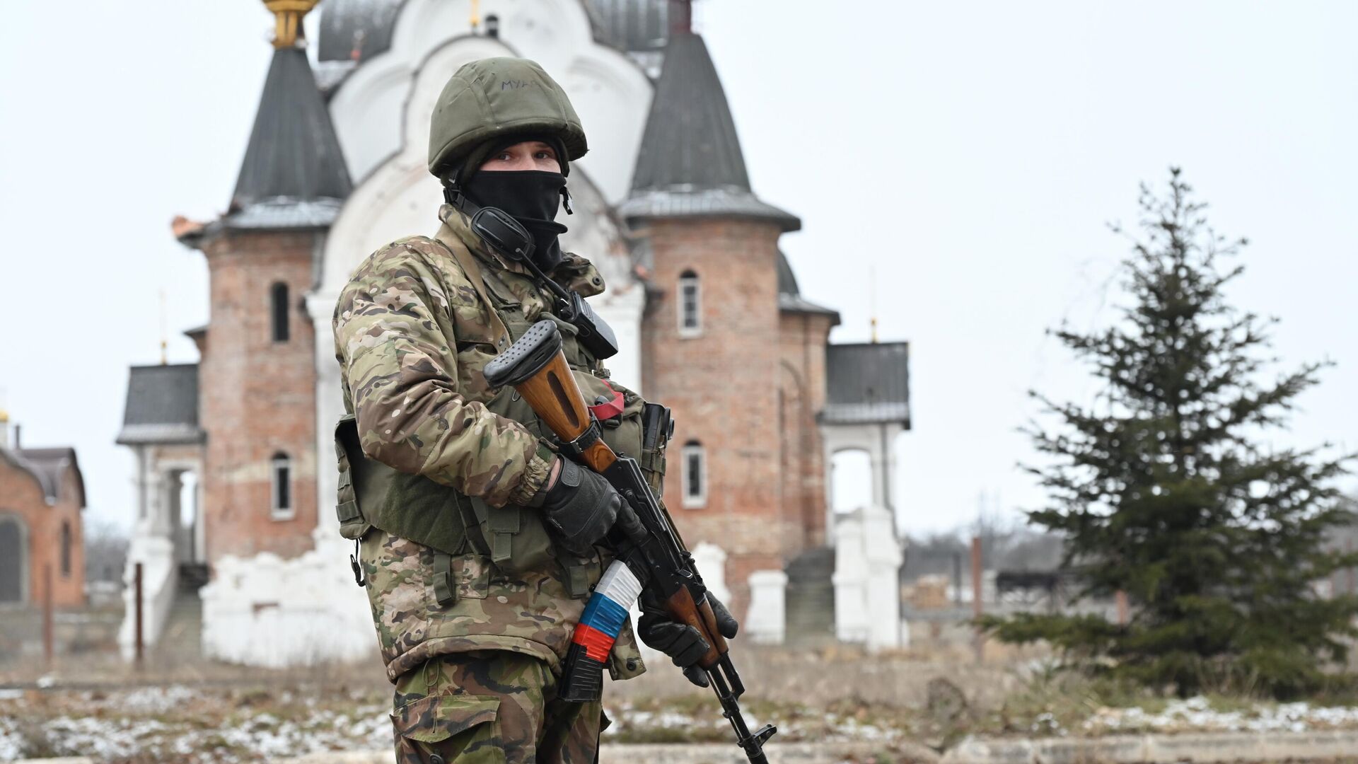 Боец подразделения ЧВК Вагнер в Соледаре. На втором плане – Свято-Преображенский храм. - РИА Новости, 1920, 14.03.2023