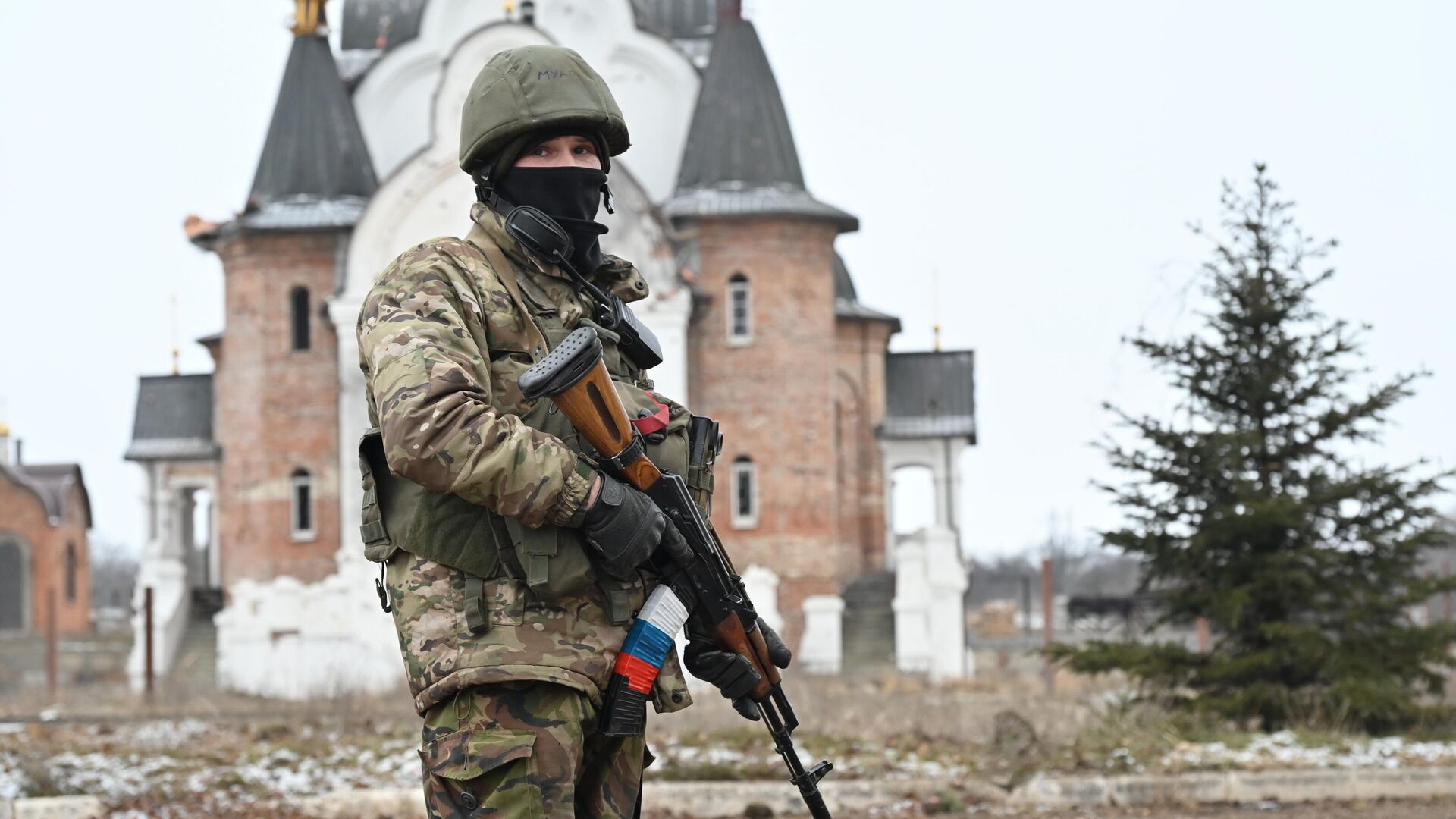 Боец подразделения ЧВК Вагнер в Соледаре. На втором плане – Свято-Преображенский храм. - РИА Новости, 1920, 14.03.2023