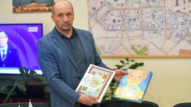 Глава администрации Энергодара Эдуард Сеновоз с книгами, собранными Следственным департаментом МВД России, для передачи в Центральную библиотеку города Энергодара. Архивное фото