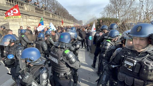 Сотрудники полиции на акции протеста против пенсионной реформы на одной из улиц в Париже