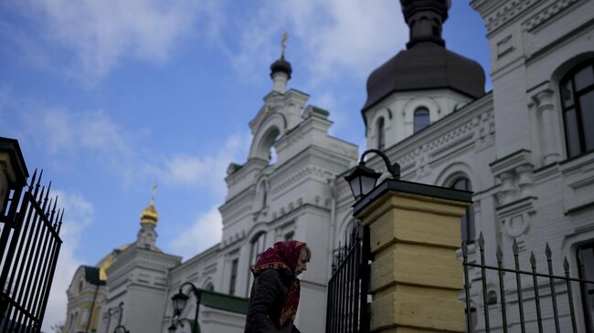 Женщина проходит мимо Киево-Печерской лавры в Киеве