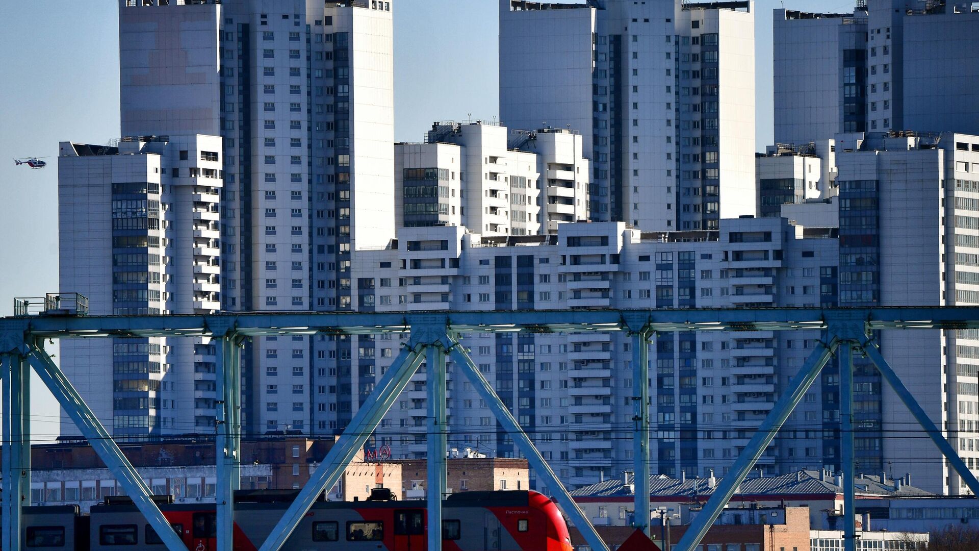 Вид на электропоезд на участке Московского центрального кольца на фоне домов в Нагатинском затоне в Москве - РИА Новости, 1920, 28.10.2025