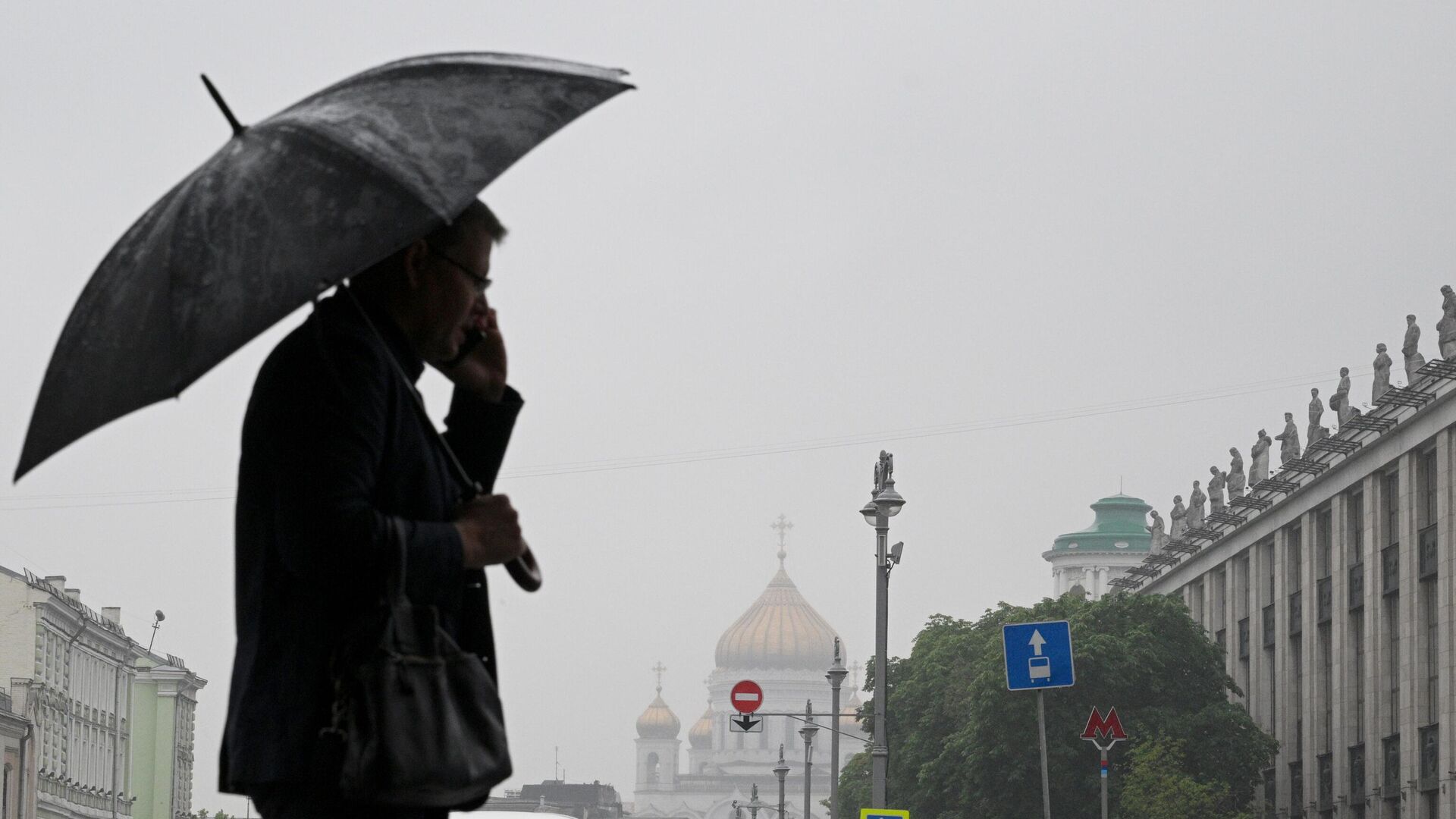 Мужчина с зонтом в дождливую погоду на одной из улиц в Москве - РИА Новости, 1920, 18.07.2023