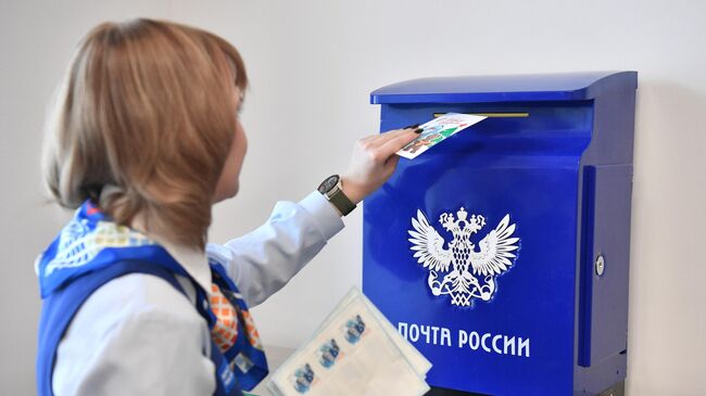 Девушка опускает письмо в почтовый ящик. Архивное фото