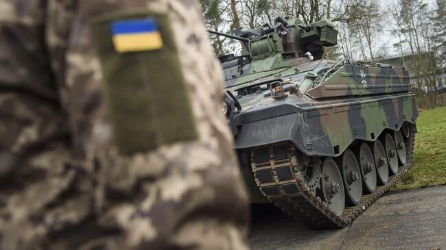 Украинский военнослужащий перед боевой машиной пехоты Marder на полигоне немецкого Бундесвера в Мюнстере