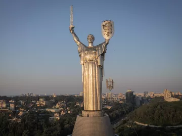 Рабочие устанавливают герб Украины на монумент Родина-мать в Киеве