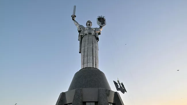 Рабочие устанавливают герб Украины на монумент Родина-мать в Киеве