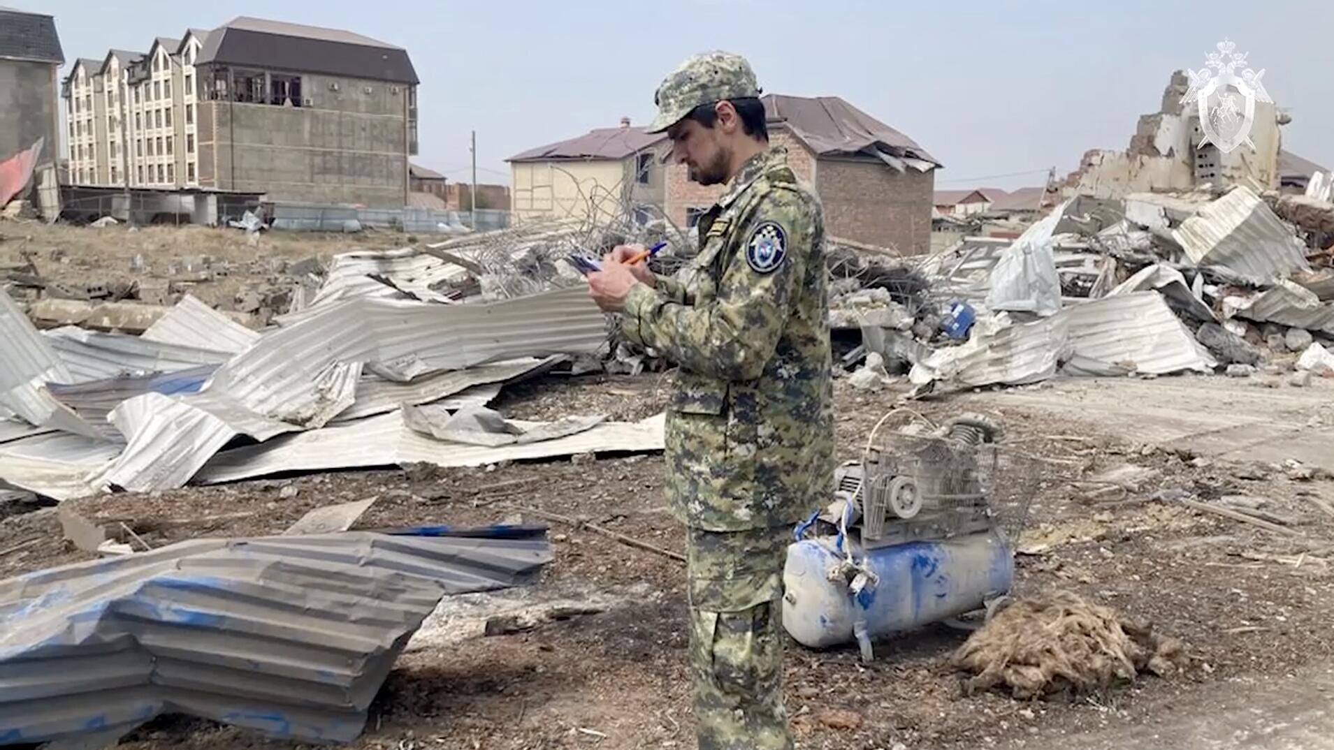 Сотрудник СК на месте взрыва в автосервисе под Махачкалой. Кадр видео - РИА Новости, 1920, 15.08.2023