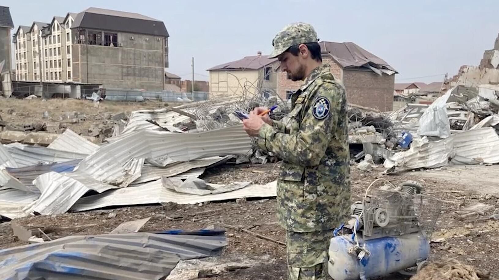 Сотрудник СК на месте взрыва в автосервисе под Махачкалой. Кадр видео - РИА Новости, 1920, 15.08.2023