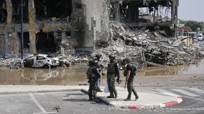 Израильские полицейские на фоне разрушенного здания в Сдероте