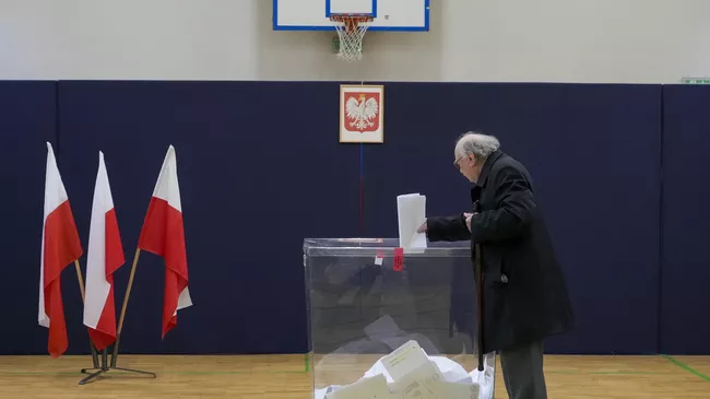 Мужчина голосует на парламентских выборах в Варшаве, Польша