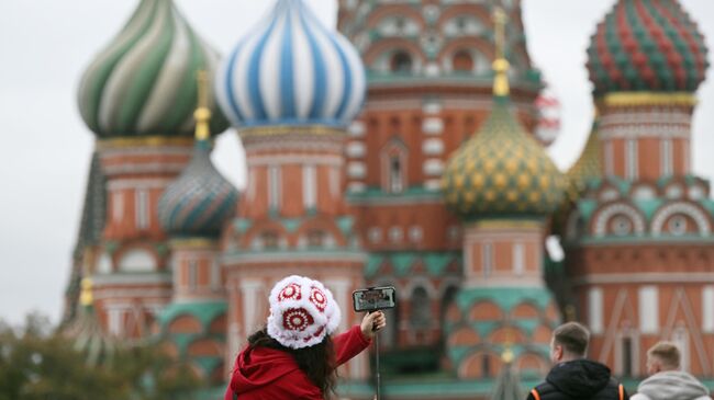 Девушка фотографируется на Красной площади в Москве