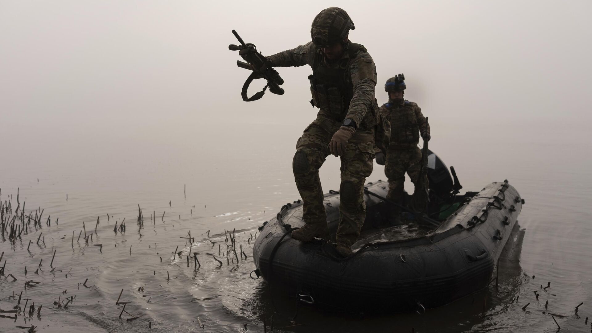 Украинский военнослужащий выпрыгивает из лодки на берег Днепра под Херсоном - РИА Новости, 1920, 18.11.2023