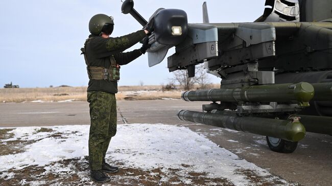 Военнослужащий группировки войск Центр ВС РФ подготавливает разведывательно-ударный вертолет Ка-52 к вылету для нанесения удара и выполнению боевых задач в зоне СВО