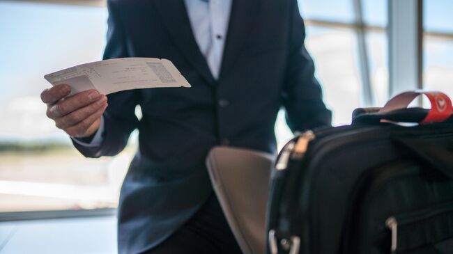 Мужчина с багажом и билетом на самолет