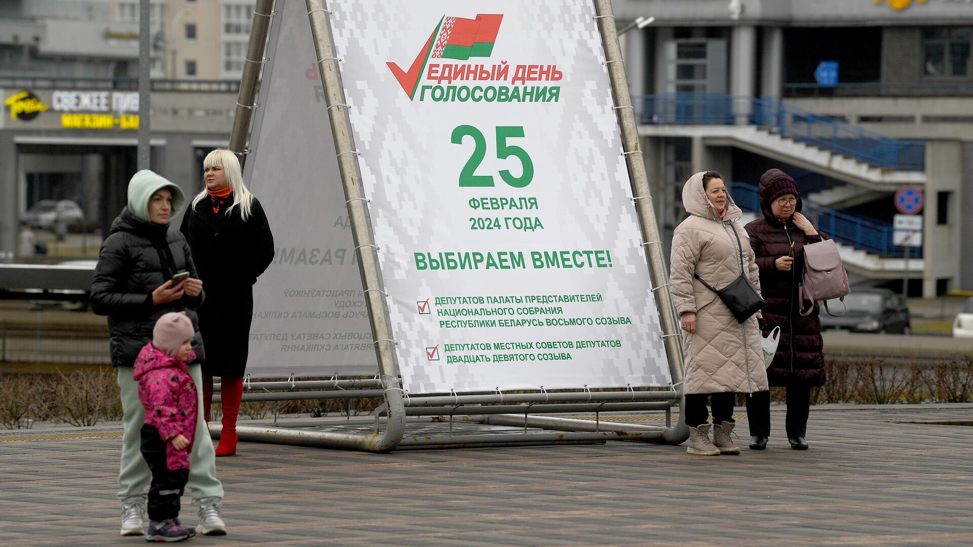 Горожане у агитационного предвыборного баннера в Единый день голосования на улице в Минске - РИА Новости, 1920, 25.02.2024