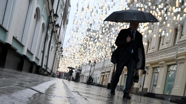 Мужчина под дождем в Москве. Архивное фото