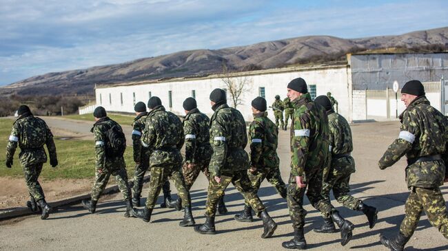 Украинские солдаты выходят с территории военной базы в поселке Перевальное. Архивное фото