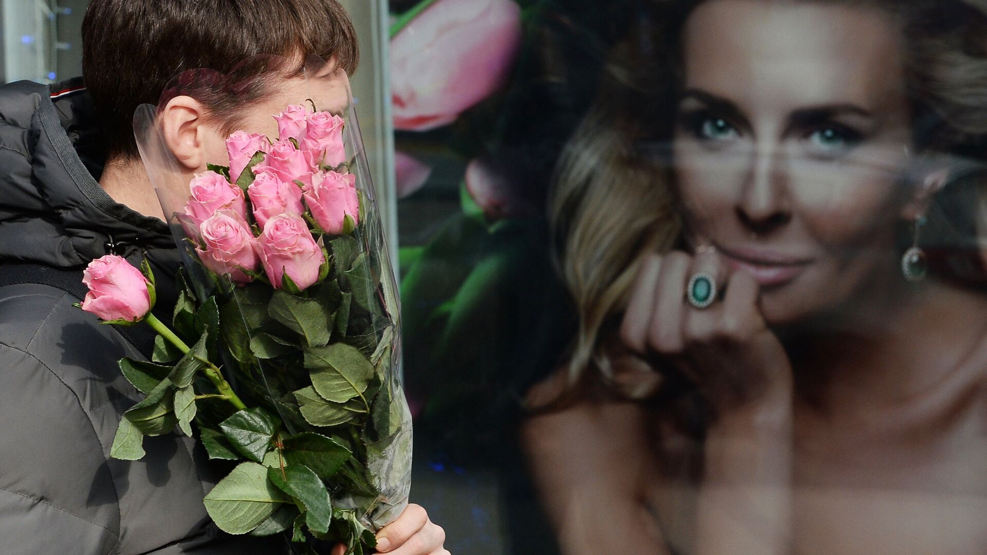 Мужчина с букетом цветов у рекламного постера - РИА Новости, 1920, 25.11.2014