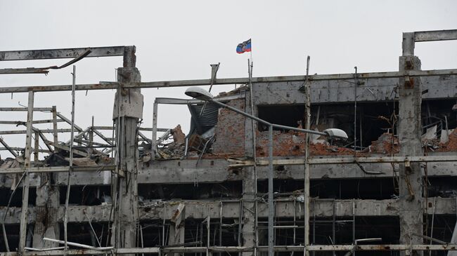 Флаг Донецкой народной республики над разрушенным зданием аэропорта города Донецка