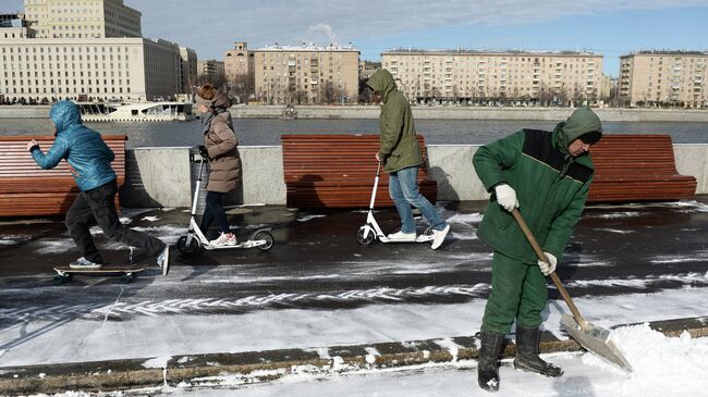 Сотрудник служб ЖКХ убирает снег